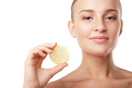 portrait of a young beautiful woman with lemon over white backgroundの写真素材
