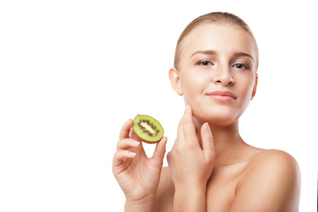 Beautiful smiling woman holding piece of kiwi. Beauty shotの写真素材