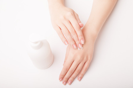 Closeup of beautiful female hand applying hand creamの写真素材