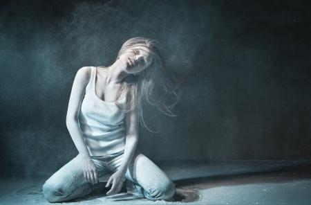 Emotional sexy Wild Woman with Flying hair and ashes in jeans over dark の写真素材