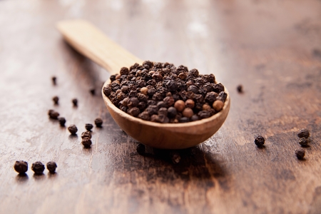 Pepper in an old wooden spoon. Spicesの写真素材