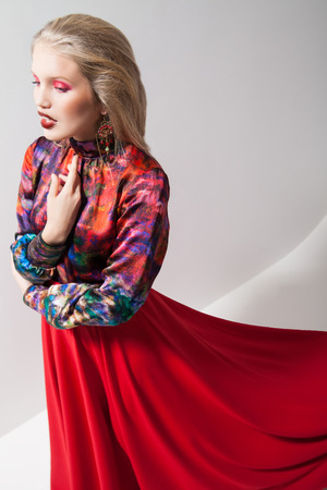 Fashion photo of young magnificent woman in red dress. Studio photoの写真素材
