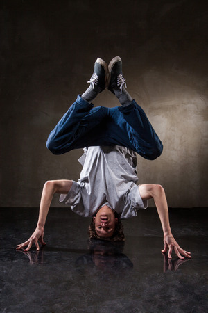 urban hip hop dancer with grunge concrete wall background texture jumping and dancingの写真素材
