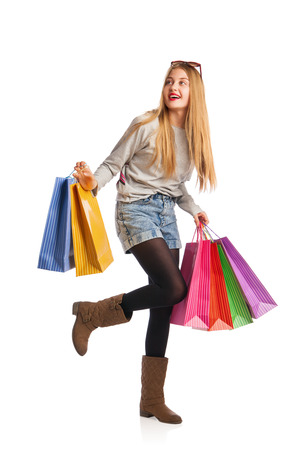Shopping woman holding shopping bags looking up to the side on white at copy spaceの写真素材