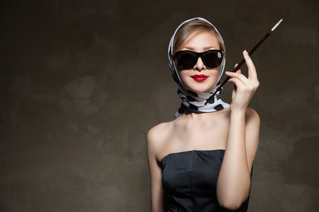 young stylish caucasian woman posing, over dark , retro stylingの写真素材