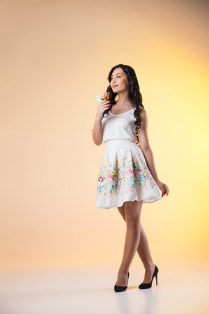 Romantic beautiful woman wearing white dress with flower on colorful の写真素材
