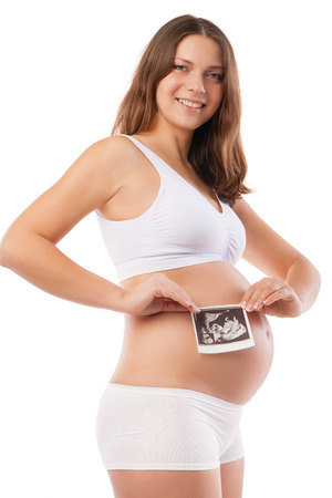 Pregnant woman is holding her stomach and a photo of her Ultrasoundの写真素材