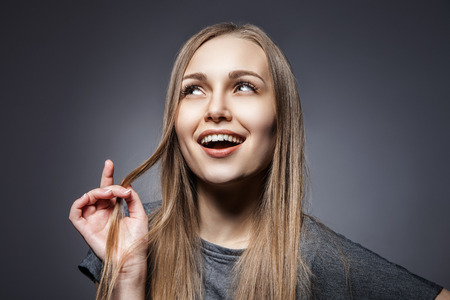 Attractive woman looking up over dark grey backgroundの写真素材