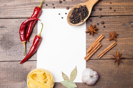 blank paper for recipes with ingredients, pasta, pepper and spices on wooden backgroundの写真素材