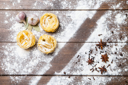 Wooden rolling pin with remnants of flour and pasta on old grainy textured wood surfaceの写真素材