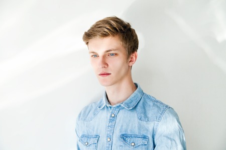 Handsome young man in casual wear standing against grey backgroundの写真素材