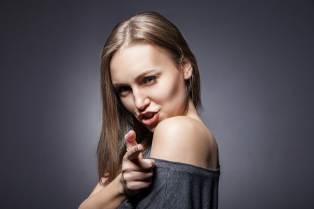 Young Beautiful Woman pretending to shoot with her fingerの写真素材