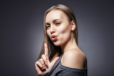 Young Beautiful Woman pretending to shoot with her fingerの写真素材