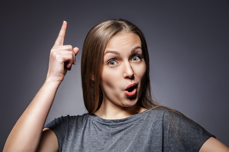 Woman having a good idea on dark grey backgroundの写真素材