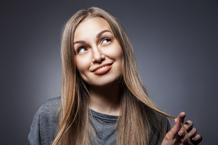 Attractive woman looking up over dark grey backgroundの写真素材