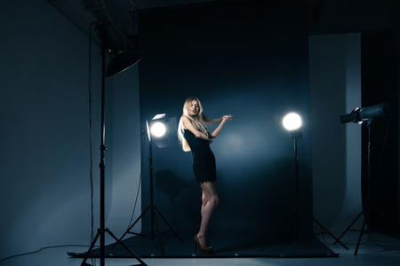 Beautiful female model posing at studio in the light flashesの写真素材
