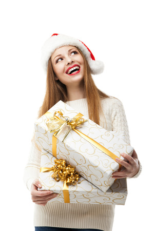 Christmas Santa hat isolated. Woman hold christmas gift. Smiling happy girl on white backgroundの写真素材
