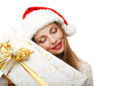 Christmas Santa hat isolated. Woman hold christmas gift. Smiling happy girl on white backgroundの写真素材