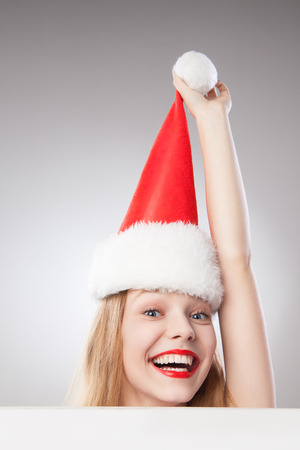 Beautiful christmas woman in santa hat holding empty board isolated on white backgroundの写真素材