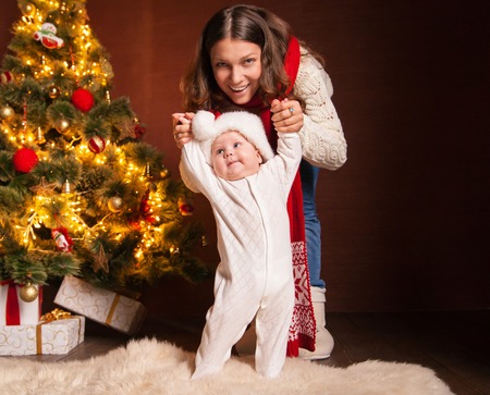 Portrait of happy mother and litle baby in santa\'s hatsの写真素材