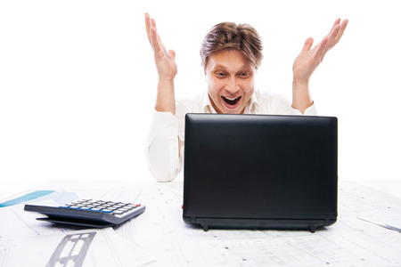 Happy young man in formal wear looking at laptop and gesturingの写真素材