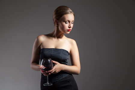 portrait of beautiful young woman with wine glass, retro stylizationの写真素材
