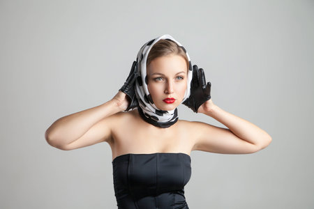 young stylish caucasian woman posing on grey background, retro stylingの写真素材