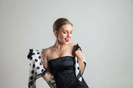 young happy stylish caucasian woman posing on grey background, retro stylingの写真素材