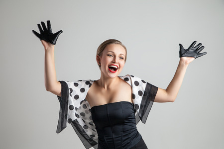 young happy stylish caucasian woman posing on grey background, retro stylingの写真素材