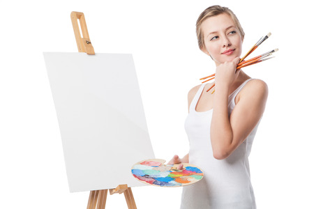 Close-up of thoughtful girl standing by canvas with a palette.Isolated.の写真素材