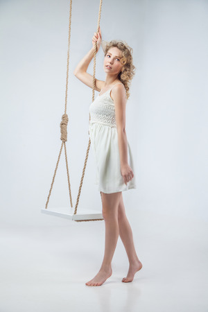 Young bare-footed girl by swing looking in the camera.の写真素材