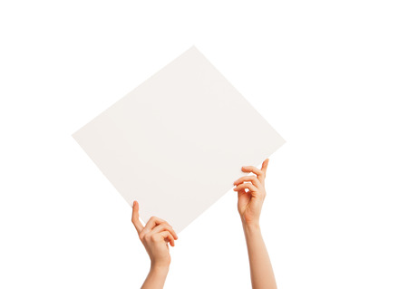 in hand a big blank sheet of white paper held diagonally from left to right. Isolated, over white background.の写真素材