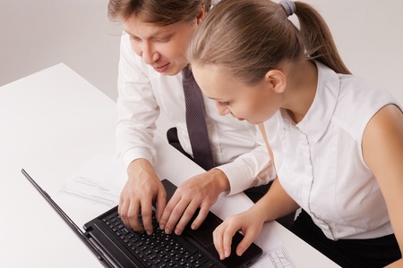 Overhead closeup of business couple using laptop. Isolated over white background.の写真素材
