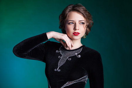 Portrait of beautiful young woman on green background