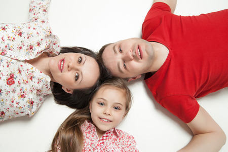 High angle portrait of happy family lying on white backgroundの写真素材