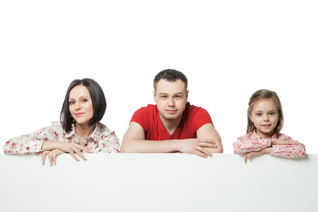 Portrait of happy family over billboard over white backgroundの写真素材