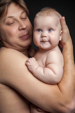Portrait of happy man holding cute baby boy and looking at him. Close upの写真素材