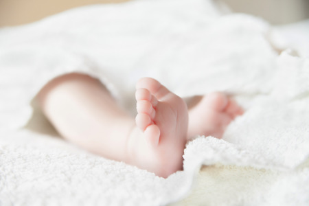 Baby feet on white coverlet. Toes.  Horizontal photoの写真素材