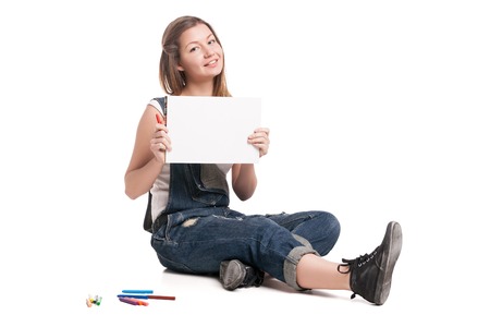 Young smiling woman  sitting  on the and show her note pad.  On a white background.の写真素材