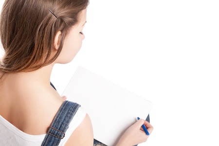Young woman  drawing in her note pad.  On a white background.の写真素材