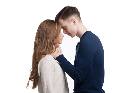Young couple in love watching each other's eyes isolated on white backgroundの写真素材