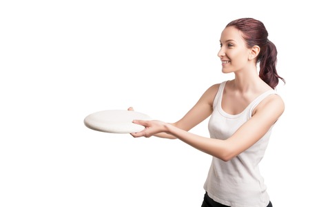 picture of young happy woman playing flying saucer over white backgroundの写真素材