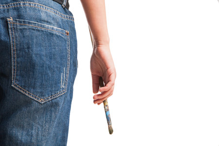 Smiling woman painter with paintbrush standing isolated over whiteの写真素材