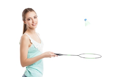 beautiful young girl playing with badminton racket in sneakers over white backgroundの写真素材