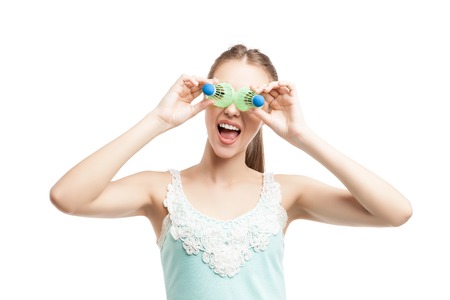 Sport woman with badminton shuttlecocks near her eyes over white backgroundの写真素材