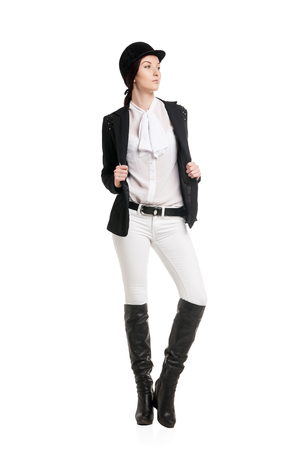 Young woman in riding clothes over white backgroundの写真素材