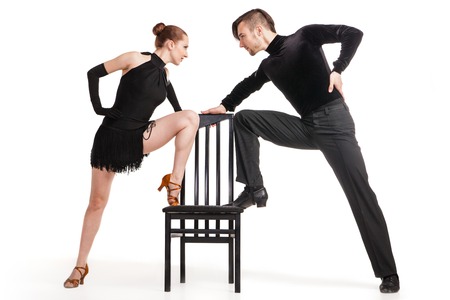 Beautiful two professional artists dancing with chair over white backgroundの写真素材