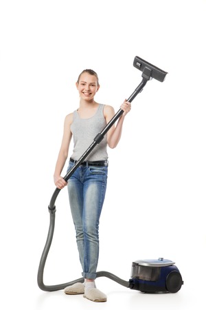 Smiling young woman with vacuum-cleaner, housewife, isolated on whiteの写真素材