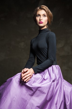 Portrait of fair-haired model with pink lips sitting in studio and looking away.の写真素材
