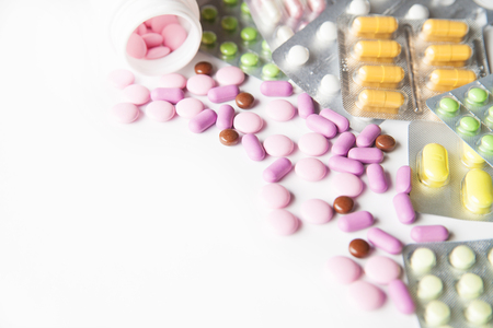 View on scattered pills and tablets in packeges on white background.From aboveの写真素材